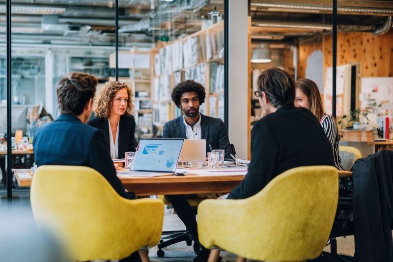 global HR team in a modern office meeting dicussing Omnipresent alternatives